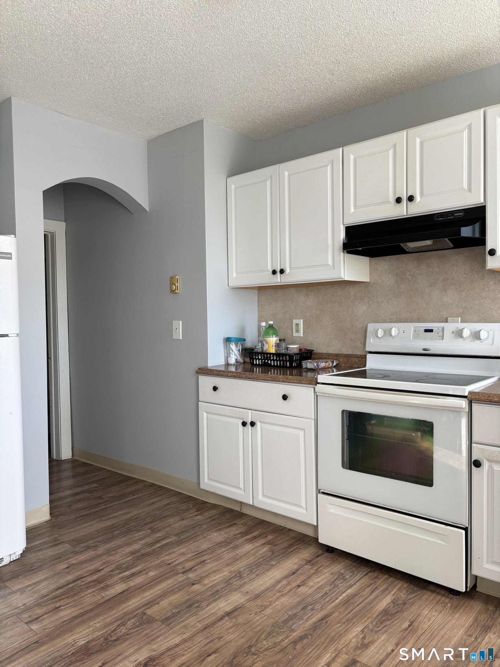 a kitchen with granite countertop wooden cabinets and white appliances