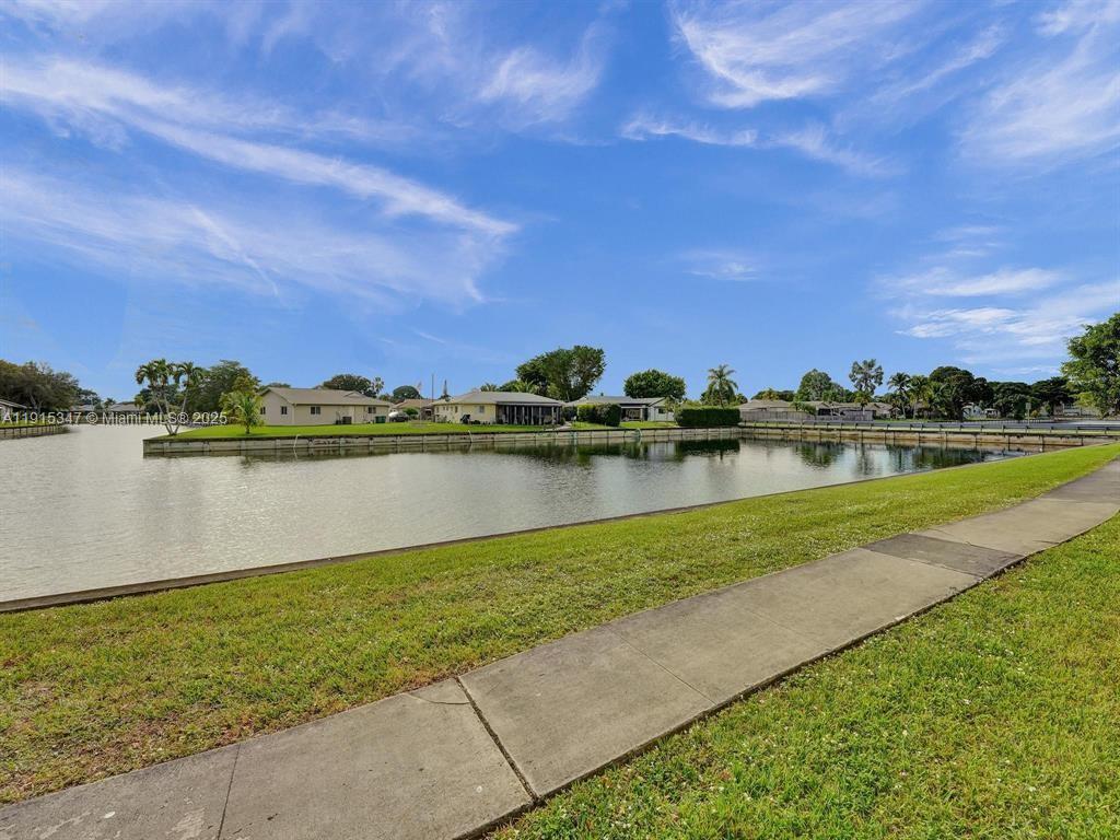 9090 Lime Bay Boulevard, Unit 106 Tamarac, FL 33321 - Photo 3 of 37 a view of a lake with a big yard