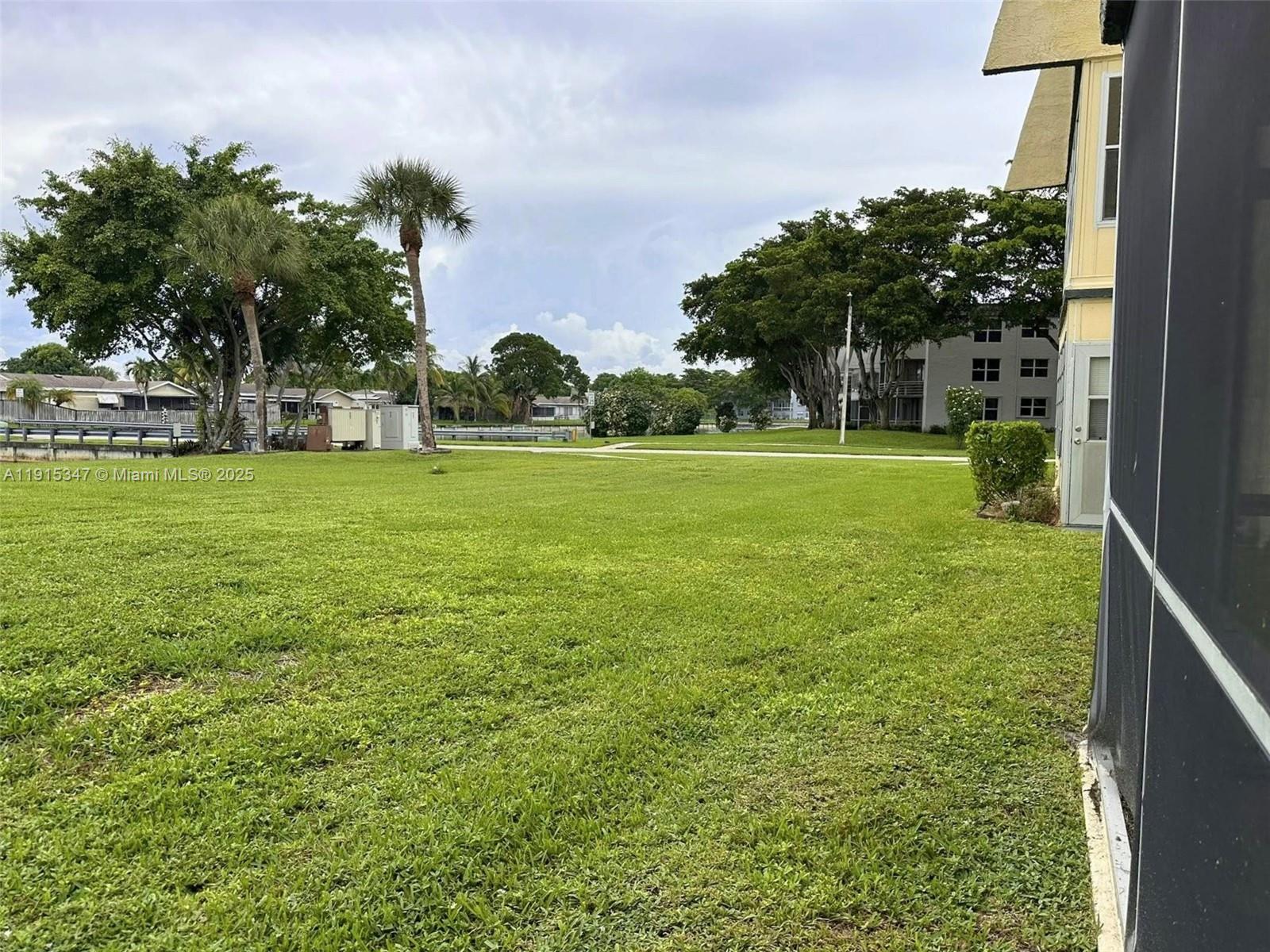 9090 Lime Bay Boulevard, Unit 106 Tamarac, FL 33321 - Photo 8 of 37 a view of a field with a tree in front of the house