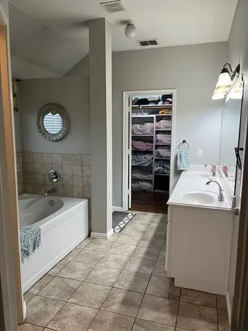 a bathroom with a tub sink and mirror