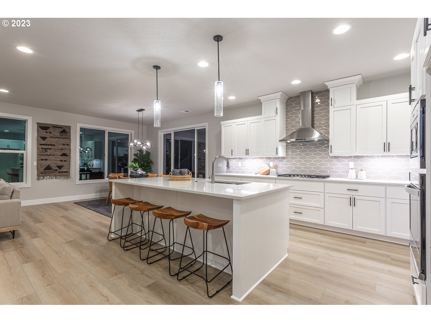 15594 Southwest Peace Avenue Tigard, OR 97224 - Photo 5 of 24 a kitchen with stainless steel appliances kitchen island granite countertop a table chairs sink and cabinets