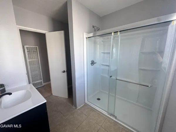 a bathroom with a shower sink and mirror