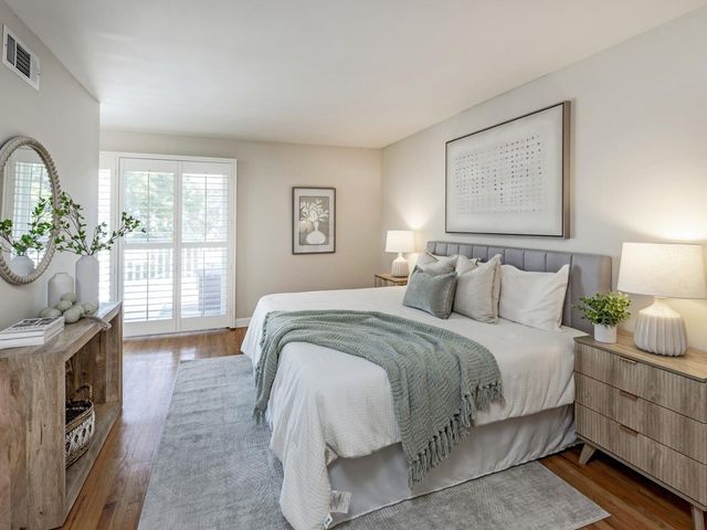 a bedroom with bed a table and window