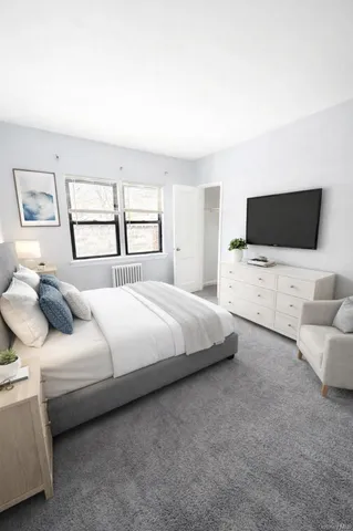 a bedroom with bed tv and window