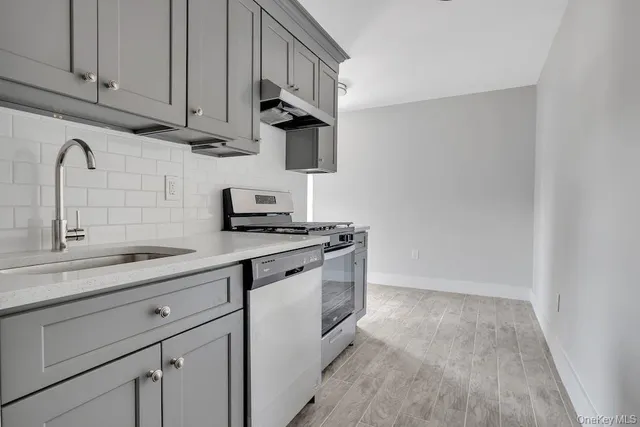 a kitchen with granite countertop white cabinets and white appliances