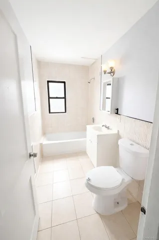 a white toilet sitting next to a bathroom sink and a window