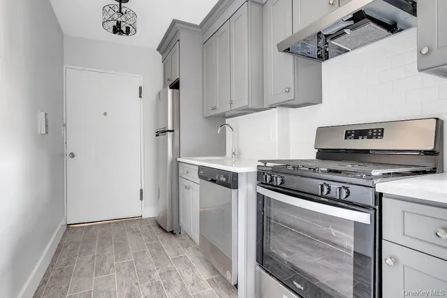 a kitchen with a stove and white cabinets