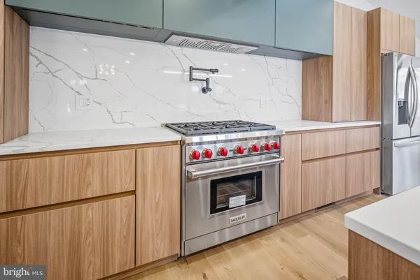 a view of a kitchen with refrigerator and a stove top oven