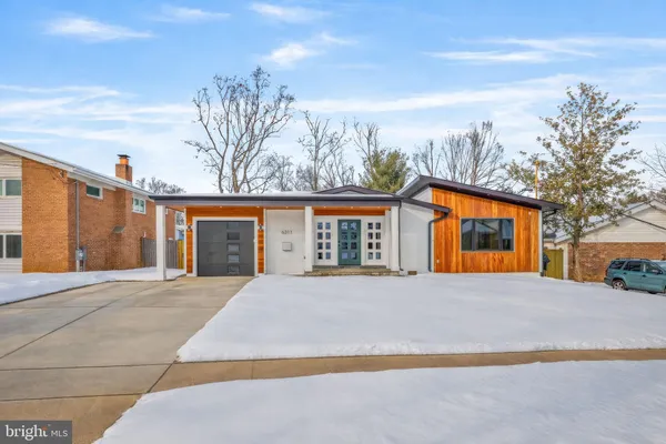a front view of house with yard and trees around