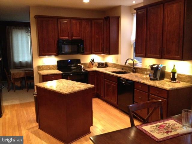 180 Walnut Creek Road Huntingtown, MD 20639 - Photo 2 of 6 a kitchen with a sink stove and cabinets