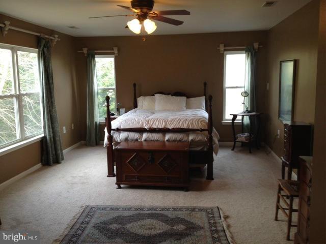 180 Walnut Creek Road Huntingtown, MD 20639 - Photo 3 of 6 a bedroom with a bed and a chandelier