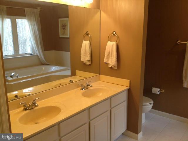 180 Walnut Creek Road Huntingtown, MD 20639 - Photo 6 of 6 a bathroom with a sink and mirror with bathtub