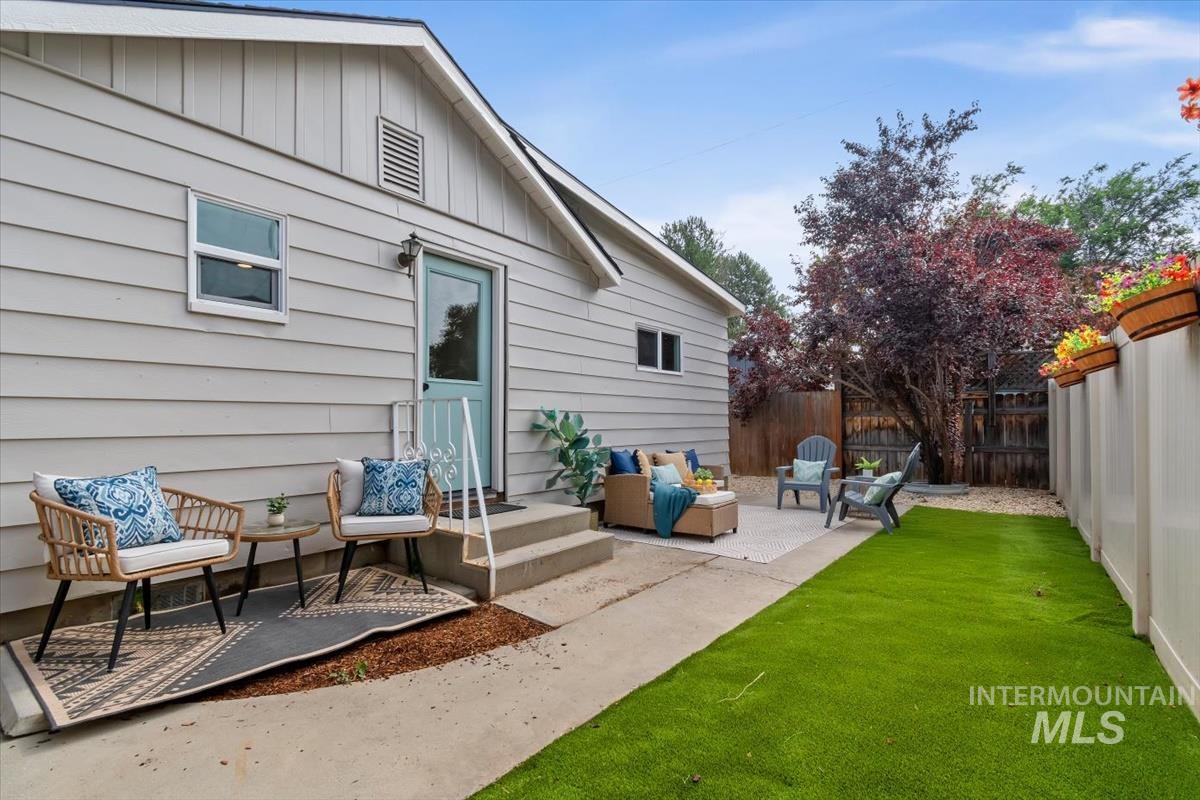3005 West Hester Street Boise, ID 83702 - Photo 29 of 32 Expansive backyard featuring a manicured lawn, concrete patio areas, and a light blue exterior door