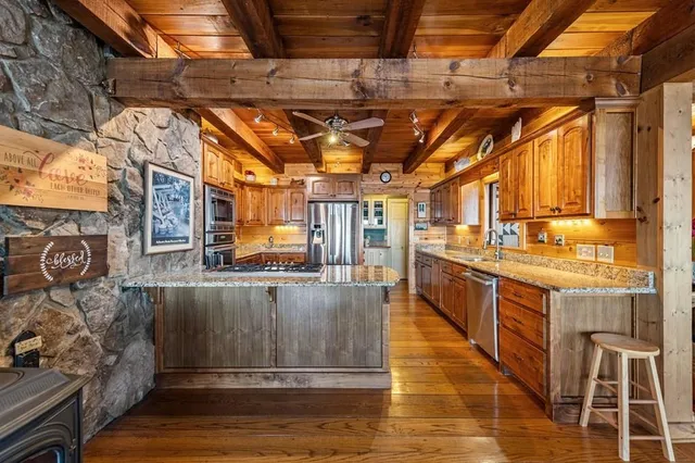 a living room with stainless steel appliances furniture and flat screen tv