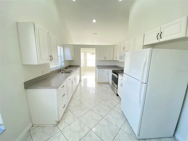 a kitchen with stainless steel appliances granite countertop a refrigerator and a stove top oven