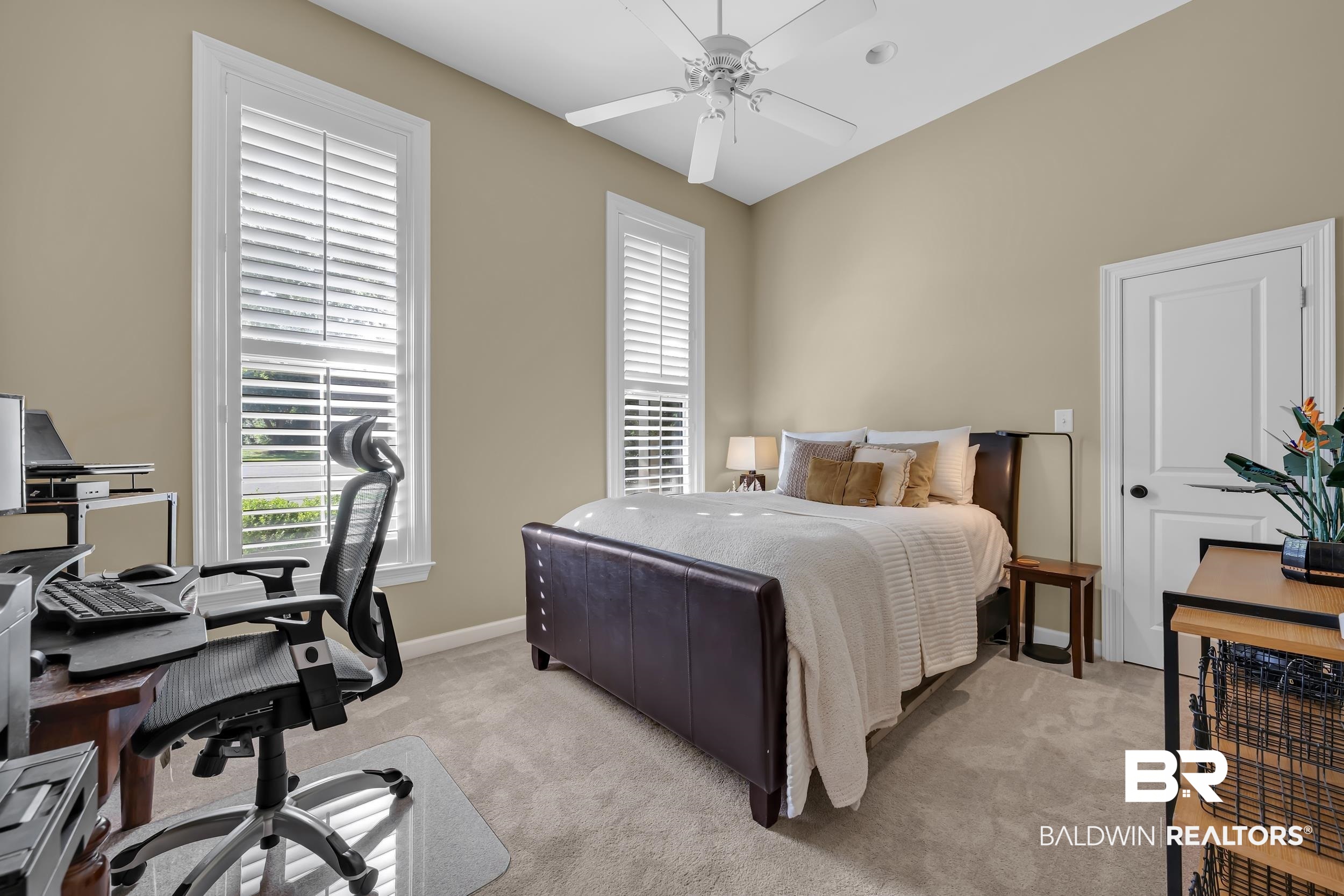 8137 Pine Run Daphne, AL 36527 - Photo 35 of 67 Carpeted bedroom featuring two large windows with white louvered shutters, a white ceiling fan, and painted beige walls