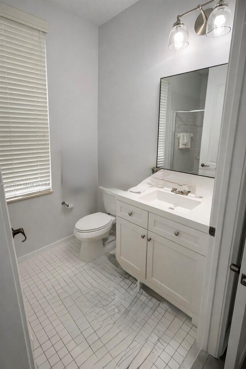 556 North West 39th Circle Boca Raton, FL 33431 - Photo 12 of 19 a bathroom with a granite countertop sink a toilet and a mirror