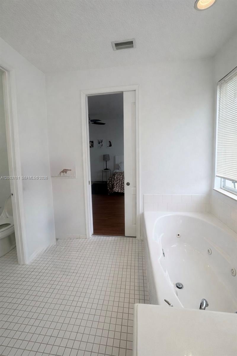 556 North West 39th Circle Boca Raton, FL 33431 - Photo 18 of 19 a bathroom with a bathtub and a shower