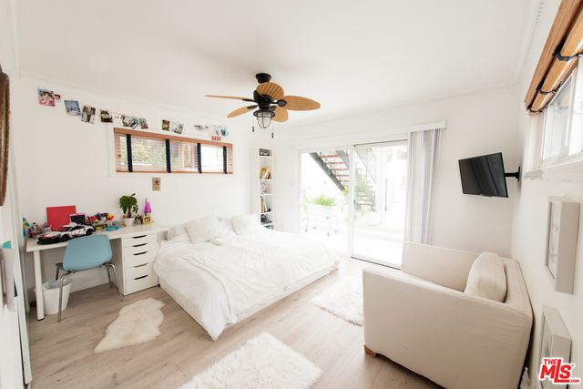 a bedroom with a bed a couch and a flat screen tv