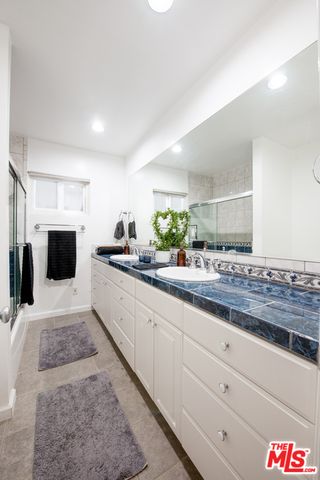 a large white kitchen with stainless steel appliances kitchen island granite countertop a sink and cabinets