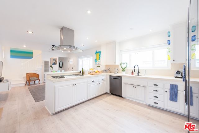 a large white kitchen with cabinets