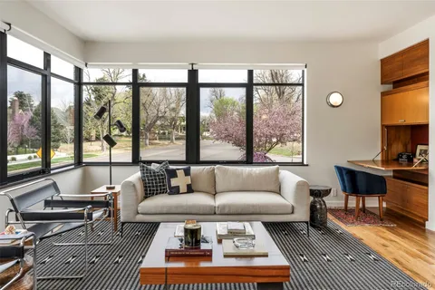 a living room with furniture a rug and a floor to ceiling window