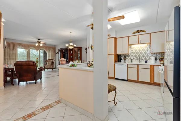 a kitchen with stainless steel appliances a sink a stove a table and chairs