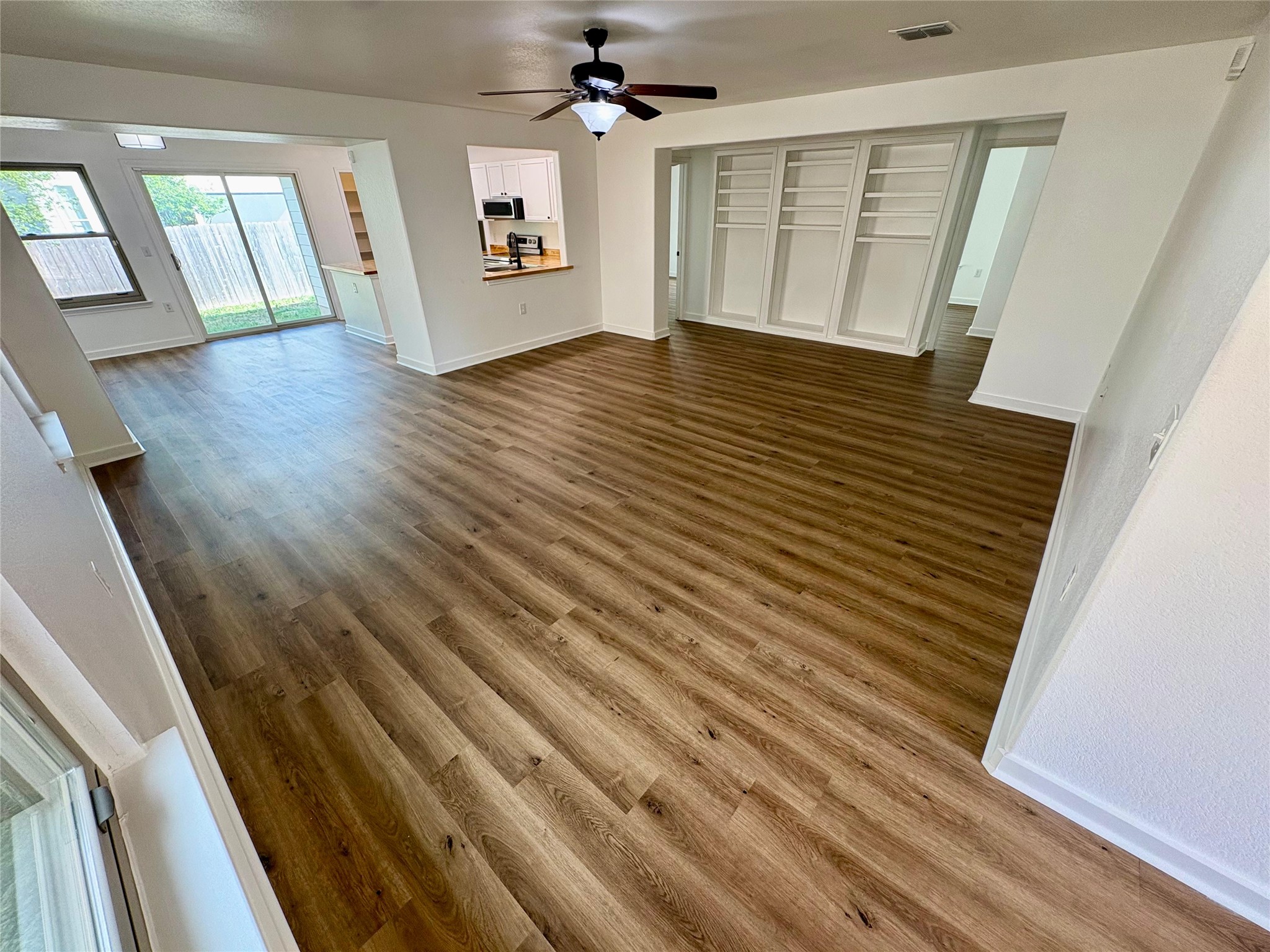 8003 Bannock Lane Austin, TX 78747 - Photo 6 of 40 Unfurnished living room featuring dark wood-style floors and ceiling fan