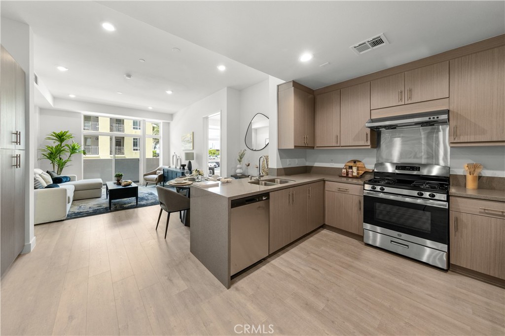 168 South Monterey Street, Unit 410 Alhambra, CA 91801 - Photo 1 of 27 a open kitchen with stainless steel appliances granite countertop a stove top oven a sink dishwasher a dining table and chairs with wooden floor