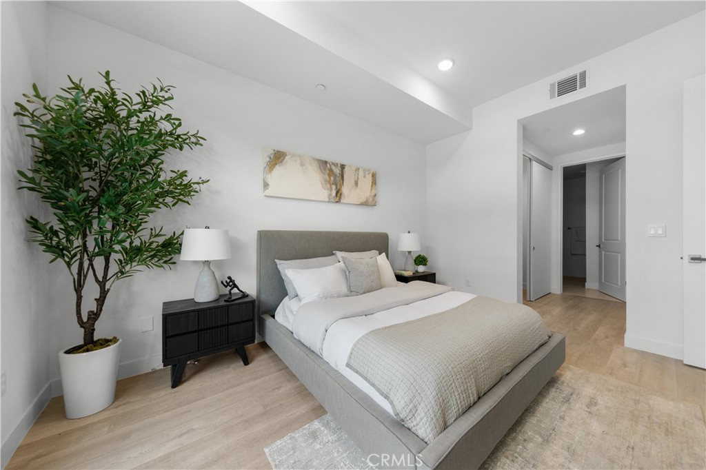 168 South Monterey Street, Unit 410 Alhambra, CA 91801 - Photo 16 of 27 a bedroom with a large bed and a potted plant