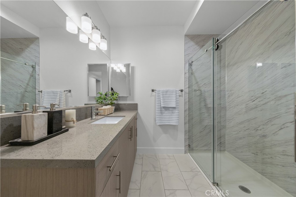 168 South Monterey Street, Unit 410 Alhambra, CA 91801 - Photo 19 of 27 a bathroom with a granite countertop sink a mirror and a shower