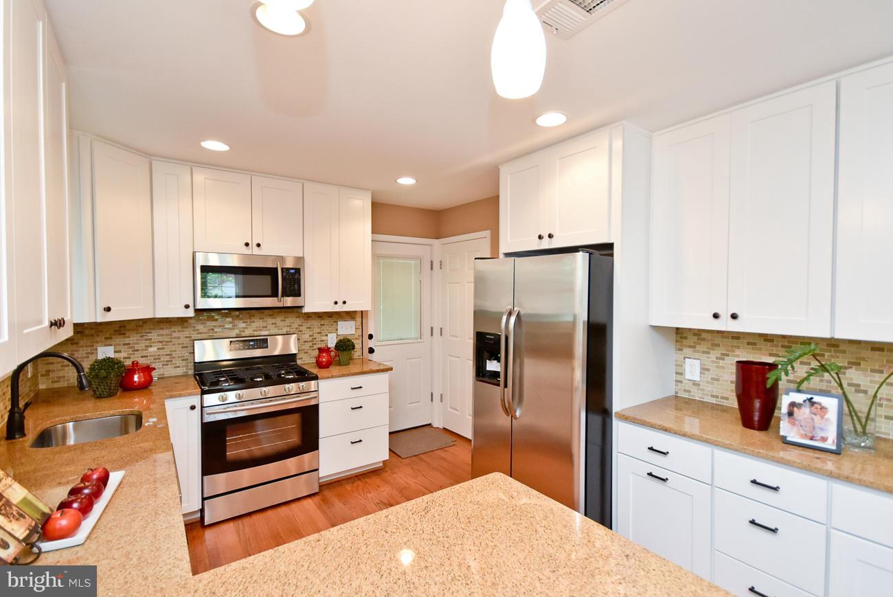 5900 Grayson Street Springfield, VA 22150 - Photo 12 of 30 a kitchen with stainless steel appliances a stove a refrigerator sink and cabinets