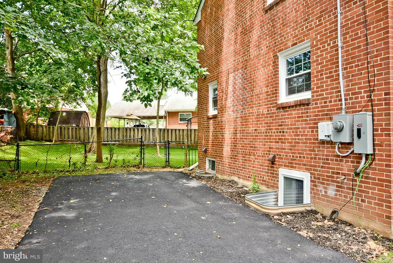 5900 Grayson Street Springfield, VA 22150 - Photo 28 of 30 a view of a backyard with brick wall and large tree
