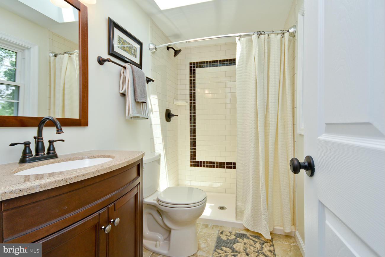 5900 Grayson Street Springfield, VA 22150 - Photo 6 of 30 a bathroom with a granite countertop sink toilet and shower