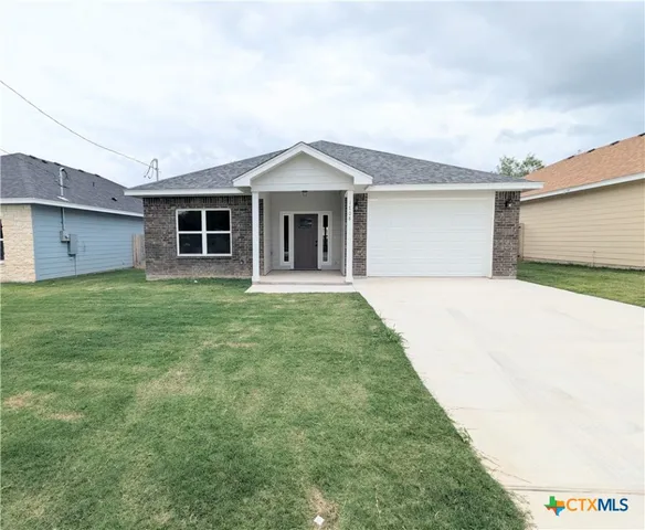 a front view of a house with yard and garage