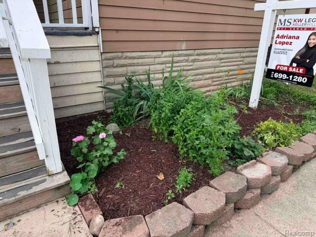 74 Pine Street River Rouge, MI 48218 - Photo 26 of 28 Foundation planting bed with fresh mulch, mature plantings, and a decorative block border