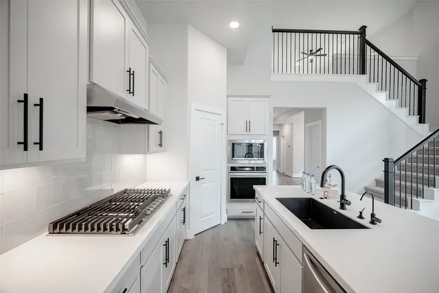 a kitchen with white cabinets and appliances