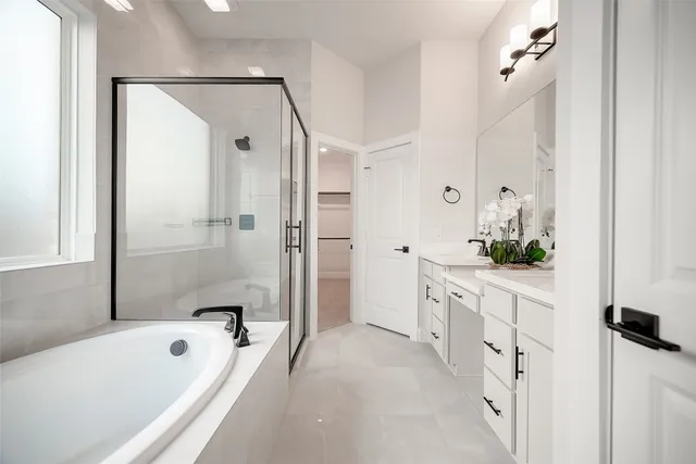 a bathroom with a granite countertop tub shower and a sink