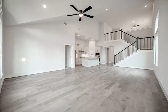 a view of an empty room and kitchen view