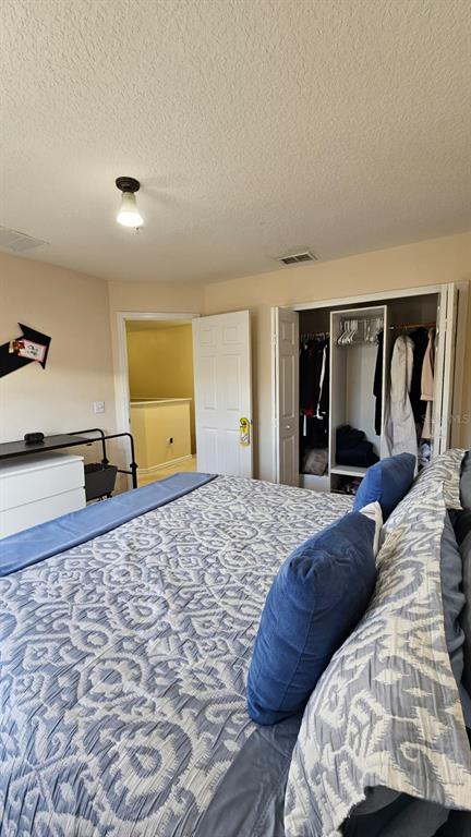 10193 Ridgebloom Avenue Orlando, FL 32829 - Photo 15 of 41 a bedroom with a large bed and a dresser