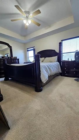 a spacious bedroom with a bed and a chandelier