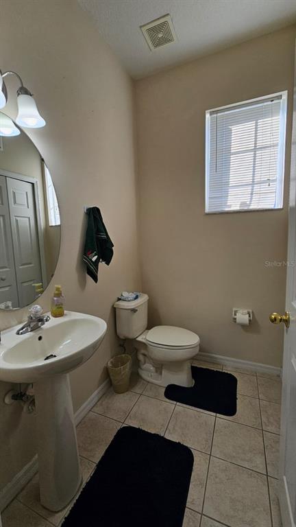 10193 Ridgebloom Avenue Orlando, FL 32829 - Photo 24 of 41 a bathroom with a toilet sink and mirror
