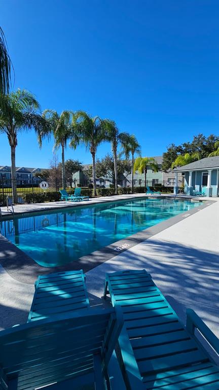 10193 Ridgebloom Avenue Orlando, FL 32829 - Photo 35 of 41 a view of a swimming pool with a table and chairs under an umbrella