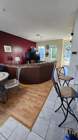 a living room with furniture and a dining table with rug