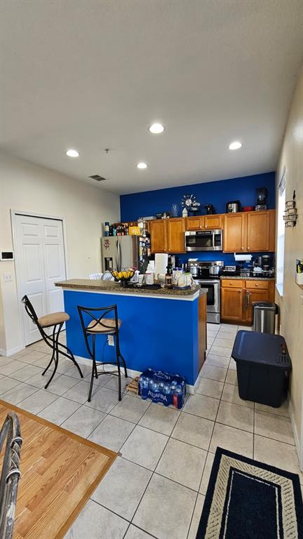 10193 Ridgebloom Avenue Orlando, FL 32829 - Photo 7 of 41 a kitchen with stainless steel appliances kitchen island granite countertop a sink and chairs