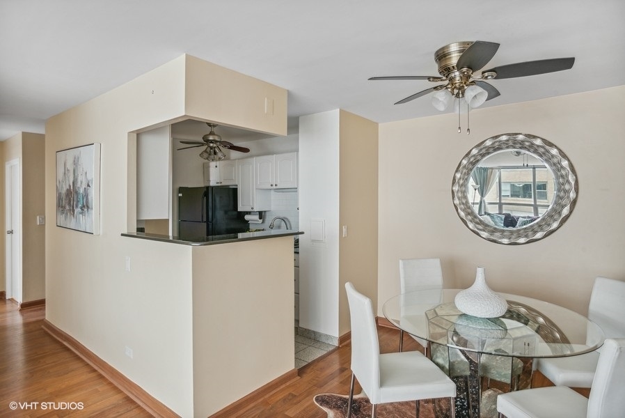 6171 North Sheridan Road, Unit 1204 Chicago, IL 60660 - Photo 4 of 15 a kitchen with stainless steel appliances a table and chairs
