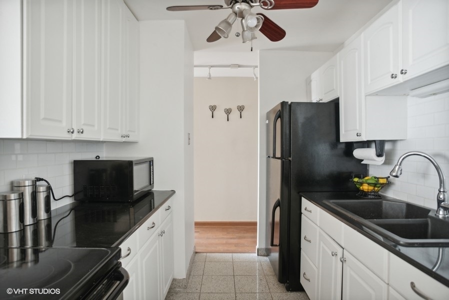 6171 North Sheridan Road, Unit 1204 Chicago, IL 60660 - Photo 6 of 15 a kitchen with stainless steel appliances granite countertop a refrigerator and a sink