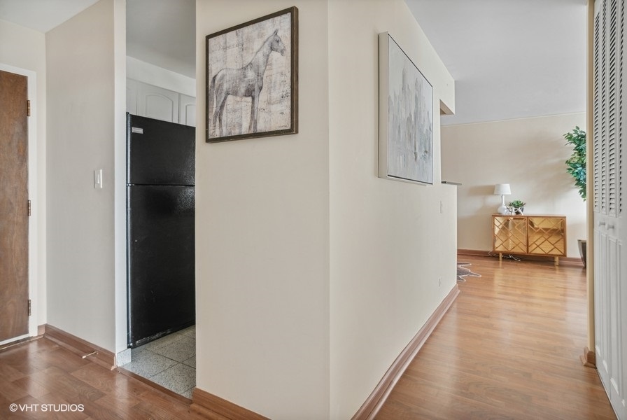6171 North Sheridan Road, Unit 1204 Chicago, IL 60660 - Photo 9 of 15 a view of a hallway to a bedroom with wooden floor and furniture