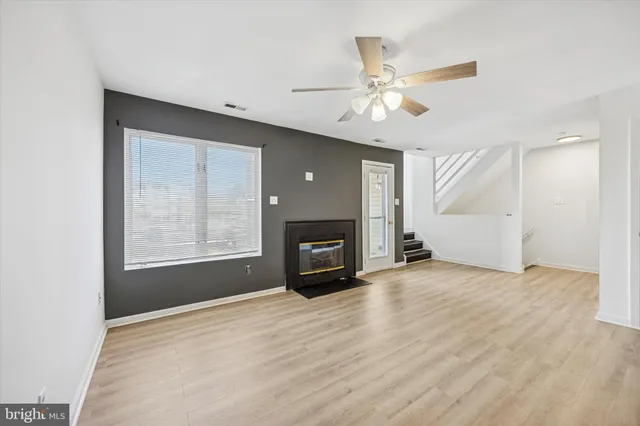 a view of an empty room with window and a fireplace