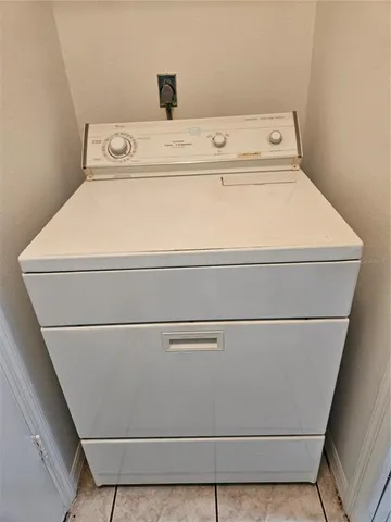 a view of a white house with a large tree